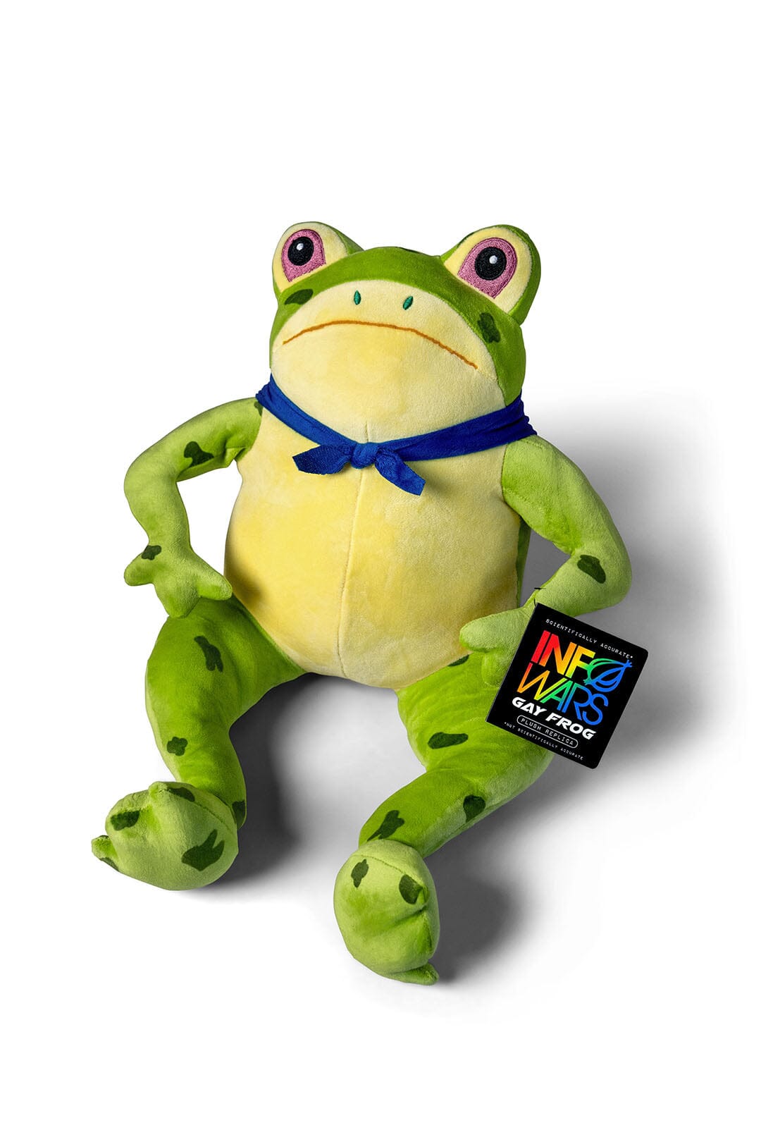 A green and yellow plush Gay Frog Collectible with with a blue bandana bow tied around their neck, sitting against a white background. A black hangtag on the leg reads 'InfoWars Gay Frog'.