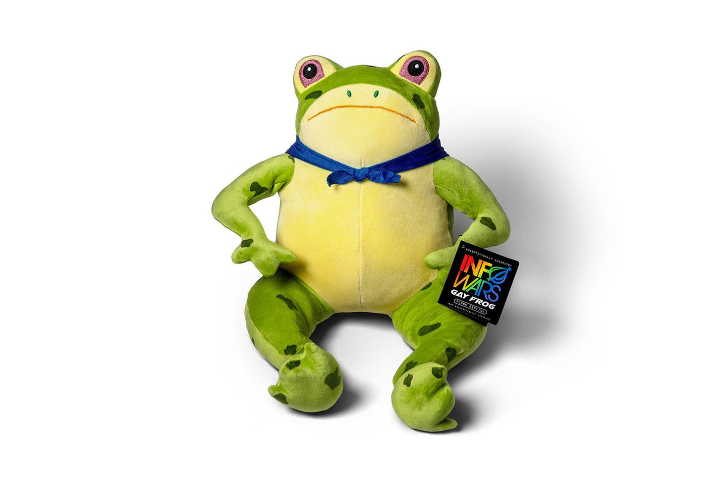 A green and yellow plush InfoWars Gay Frog with a blue handkercheif tied around his neck, posed sitting against a white background. A black hangtag with a colorful InfoWars Gay Frog logo is attached to its right leg.